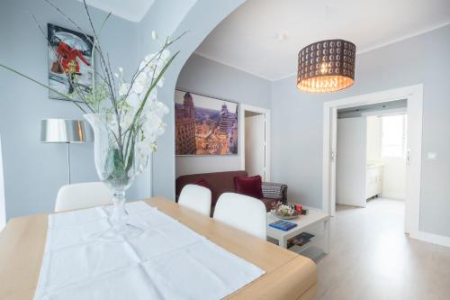 a dining room with a table with a vase of flowers at 14 Mirasierras in Madrid