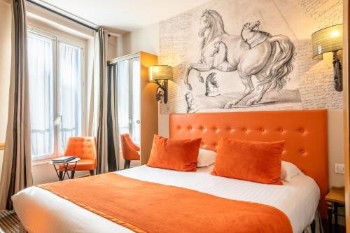 A bed or beds in a room at Hôtel des Ducs D'Anjou