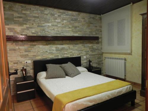 - une chambre avec un lit et un mur en briques dans l'établissement Turismo Rural Santa Lucia, à Ateca