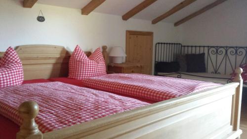 a bedroom with two beds with red and white sheets at Alpenblümchen Apts. der Kornauer Stuben in Oberstdorf