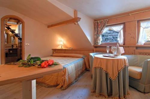 a bedroom with a bed and a table with flowers on it at Hotel San Lorenzo in Bormio