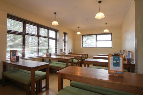 a living room filled with tables and chairs at YHA Snowdon Llanberis in Llanberis