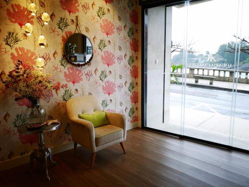 a living room with a chair and a mirror at Hotel Boutique Aquaria Caneliñas in Portonovo