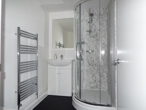 a bathroom with a shower and a sink at Corner House Guest House in Bideford