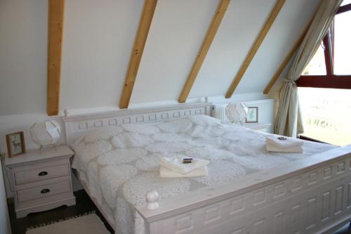 ein Schlafzimmer mit einem weißen Bett und einem Fenster in der Unterkunft Apartment Jakobsweg GbR in Pettstädt