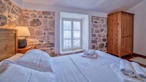 a bedroom with a bed with towels on it at Beachfront Villa Perast in Perast