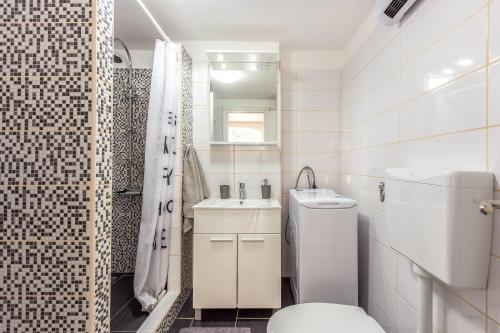 a white bathroom with a toilet and a sink at Apartment Lucija in Bakar