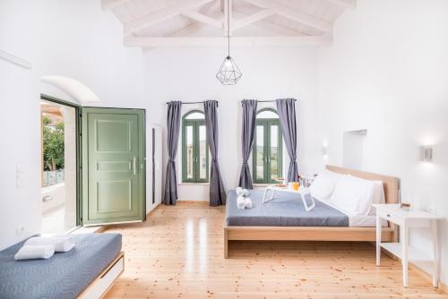 a bedroom with two beds and a green door at Fotini's House in Petrokefálion