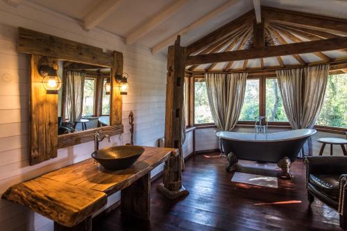 a bathroom with a tub and a wooden table at Villa Vanille in Boisseron