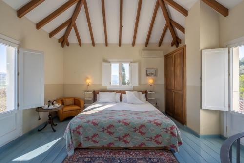 a bedroom with a bed and a chair and windows at Hotel La Fuente de la Higuera in Ronda