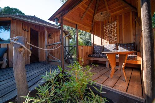 a wooden cabin with a bench on a deck at Villa Vanille in Boisseron