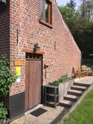 a brick building with a wooden door and stairs at 't Huizeke in Asse