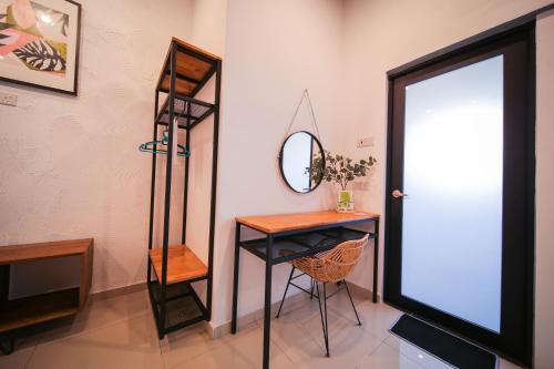 a room with a desk and a mirror and a door at The Best Hotel in Bayan Lepas - THE LOV PENANG in Bayan Lepas