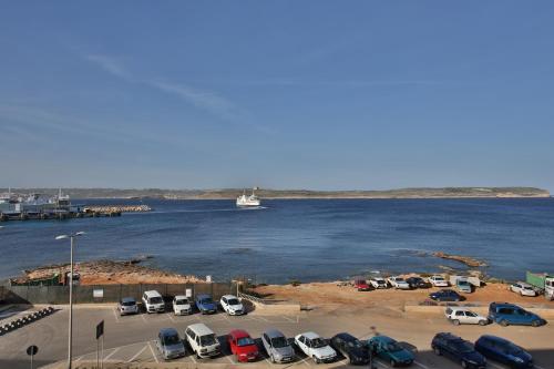 a bunch of cars parked in a parking lot by the water at Paradise Bay Resort in Mellieħa