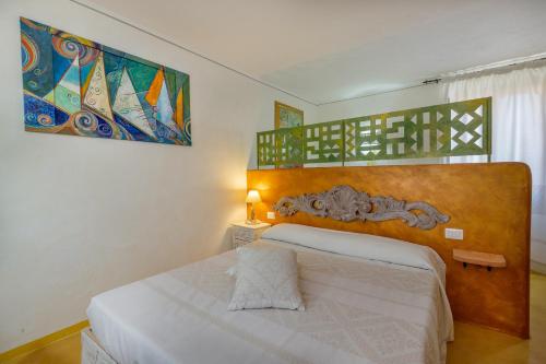 a bedroom with a bed and a painting on the wall at Palazzo Beddoro in San Pantaleo