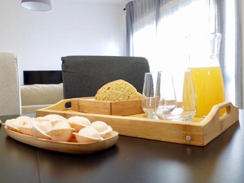 bandeja de madera con pan y copas de vino en una mesa en White Family House, en Aveiro