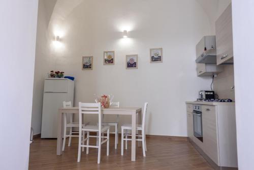 eine kleine Küche mit einem Tisch und Stühlen in einem Zimmer in der Unterkunft Capo Ognina in Catania