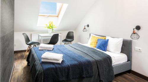 a bedroom with a bed with a blue blanket and chairs at Green Garden Residence in Krakow