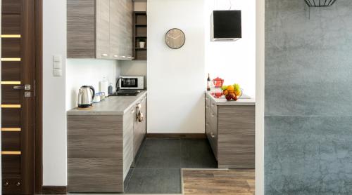 a kitchen with wooden cabinets and a counter top at Green Garden Residence in Krakow