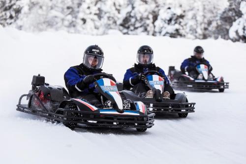 two men riding on a snowmobile in the snow at Aurora Village Ivalo in Ivalo