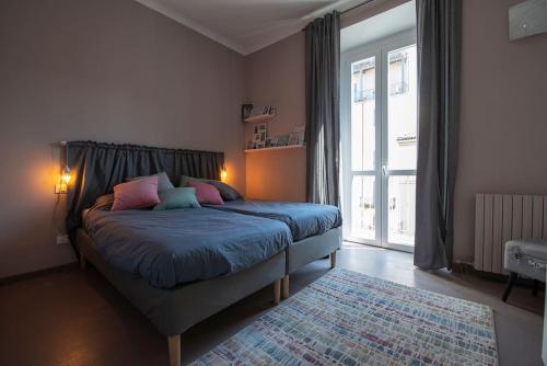 a bedroom with a bed and a large window at Anna BnB in Milan