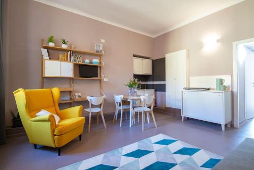 a living room with a yellow chair and a kitchen at Anna BnB in Milan