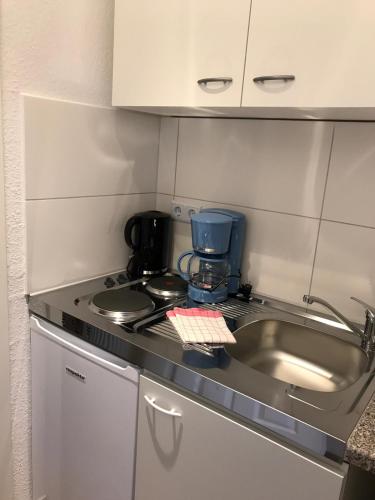 a kitchen counter with a sink and a stove at Kleine Möwe in Neßmersiel