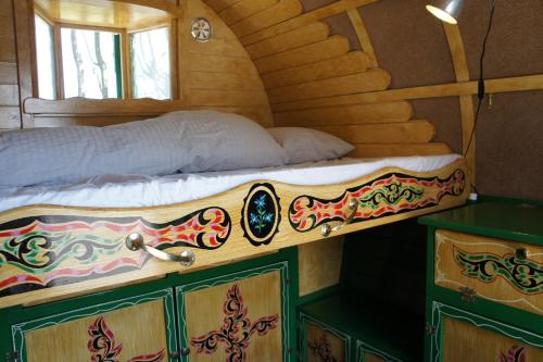 a bed in a room with a wooden cabin at Hotell Vagabond in Abbekås