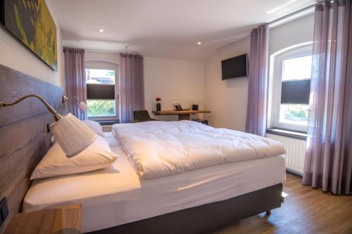a bedroom with a large bed and two windows at Valuas in Venlo