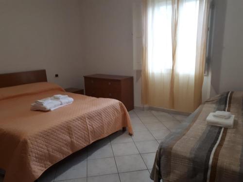 a hotel room with two beds and a window at GALLURAS B&B in Olbia
