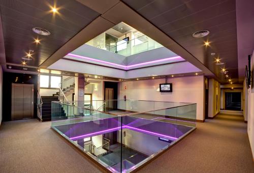 an empty room with glass and purple lighting at Dña Monse Hotel Spa & Golf in Torrevieja