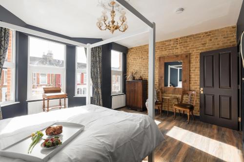 sypialnia z łóżkiem z tacą z jedzeniem w obiekcie Courcy Road - 7 bedroom - sleeps up to 22 w Londynie