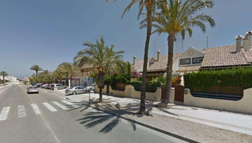 une rue bordée de palmiers et de voitures dans l'établissement Casa en el Centro de Cabo de Palos Cerca a Clubes de Buceo, à Cap de Palos