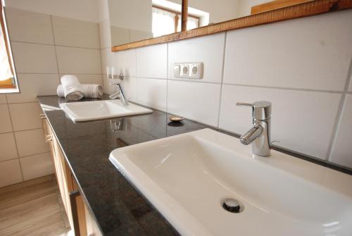 a bathroom with two sinks and a mirror at Ferienhaus "Schneider" in Maria Luggau