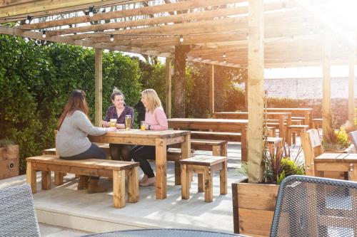 three women sitting at a picnic table under a pergola at Rashleigh Arms in St Austell