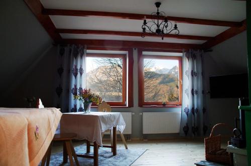 a room with a table and two windows at Willa Anna in Kościelisko