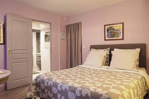 um quarto com uma cama grande e paredes roxas em Au Fil de l'Eau em Mouroux