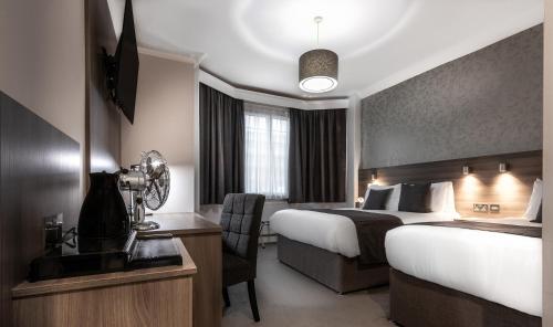 Pokój hotelowy z 2 łóżkami i biurkiem w obiekcie Qudos w mieście Salisbury