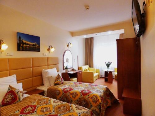 Habitación de hotel con 2 camas y escritorio en Aparthotel Adler en Cracovia
