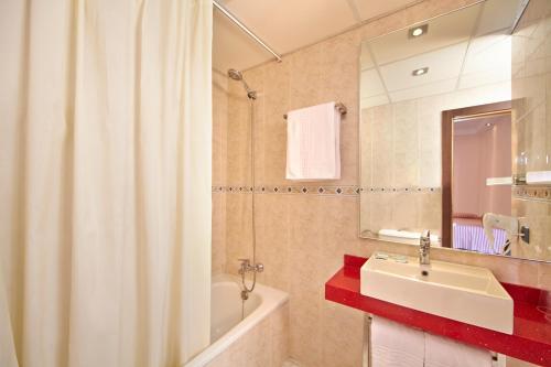 a bathroom with a sink and a shower curtain at MLL Caribbean Bay in El Arenal