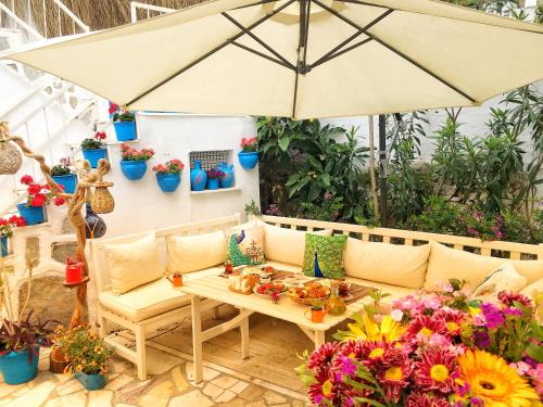 un patio con un divano e un tavolo con fiori di Bodrum Sade Pension a Bodrum City
