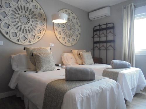 a room with two beds with white sheets at TAK Boutique Old Town in Marbella