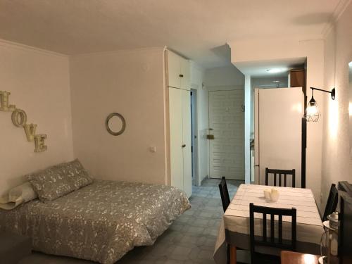 Sala de estar con cama y mesa de comedor en Beach Studio Benalmádena, en Benalmádena