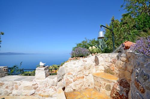 a stone retaining wall with a view of the ocean at House Dobrila in Igrane