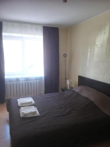 a bedroom with a bed with two towels on it at Butas Vilniaus alėjoje in Druskininkai