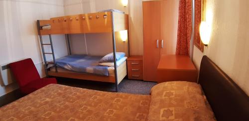 ブラックプールにあるオークビル アパートメンツの二段ベッドとベッドが備わる小さな客室です。