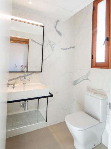 a white bathroom with a sink and a toilet at Es Palauet New duplex in Ibiza center with Dalt Vila views in Ibiza Town