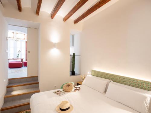 una camera da letto con un letto bianco e un cappello sopra di Es Palauet Brandnew one suite apartment in Ibiza center a Ibiza Città