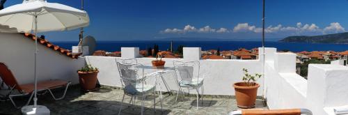 a patio with a table and chairs and an umbrella at Stella Rooms in Kardamili