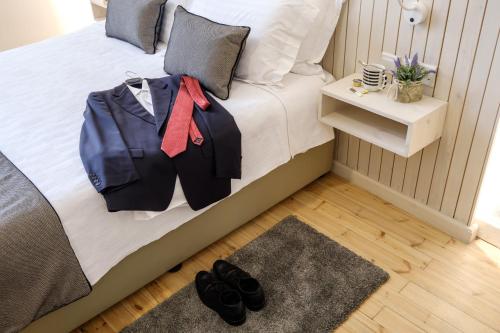 a bedroom with a bed with a suit on it at Limassol Old Town Mansion in Limassol